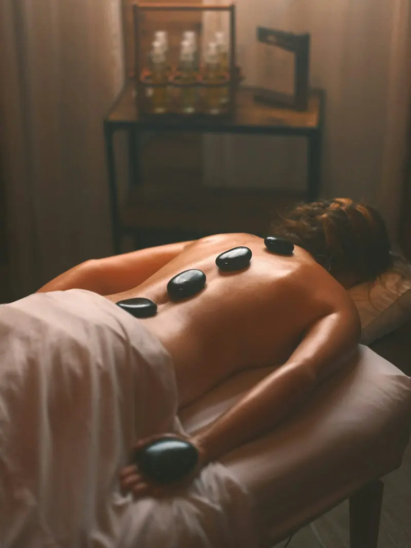 Smooth hot stones laid along a client's back