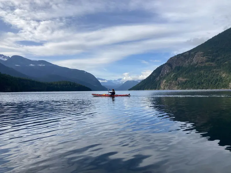 A canoe out on a lake with mountains behind