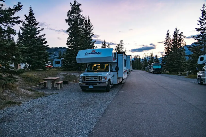 A motorhome parked at a campground at dusk