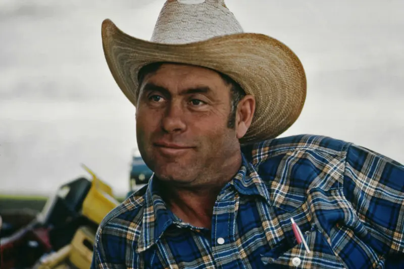 A rancher in a straw cowboy hat and plaid shirt