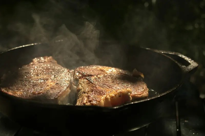 A steak searing in a cast iron skillet
