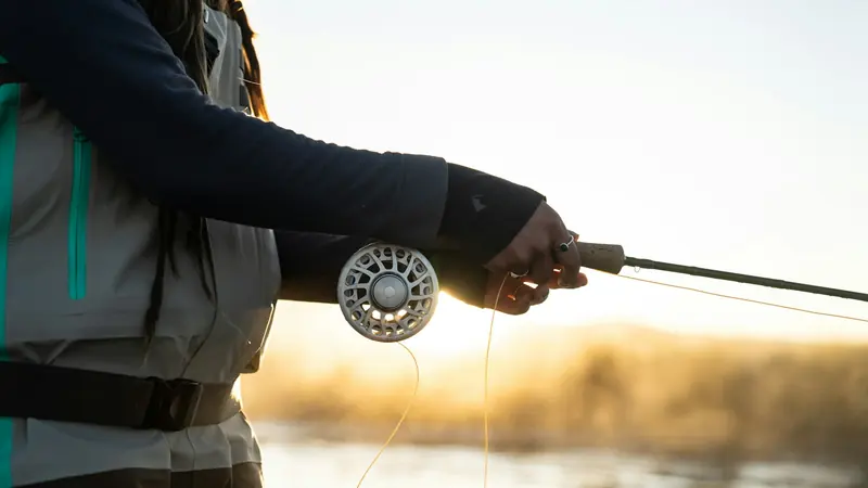 A fly reel and rod held up in the morning light