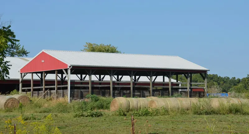 A red and white hay barn full of bales