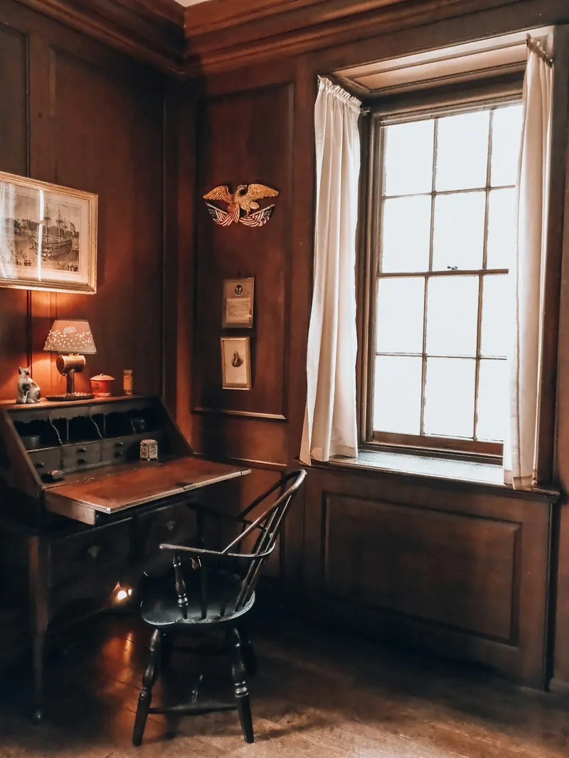 An old wood-paneled office with a writing desk by the window