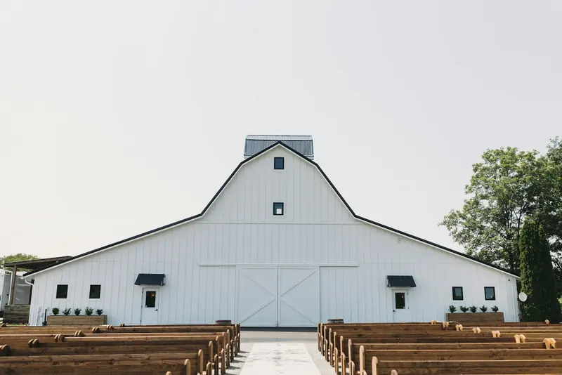 Wooden benches inside a white barn