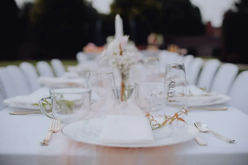 A dinner table set outside at dusk