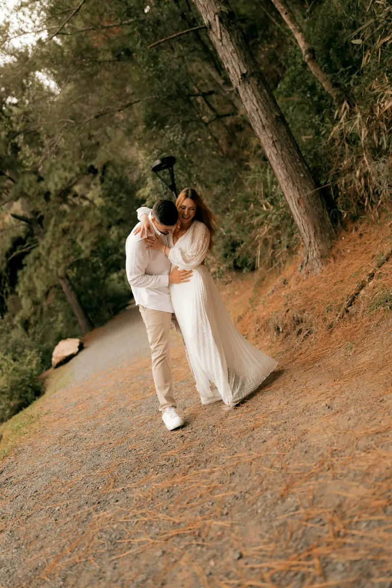 A couple holding each other on a wooded path