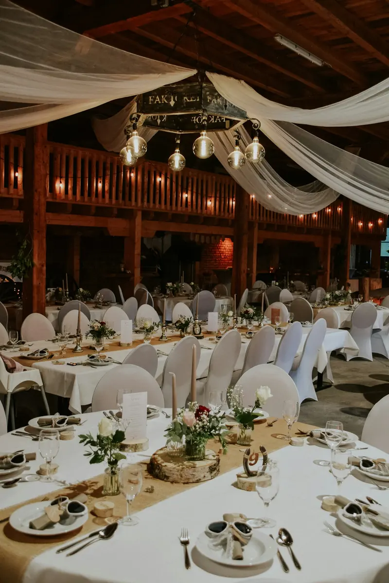 A barn set with round tables for a reception