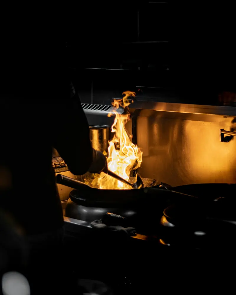 A cook working the grill in the dark