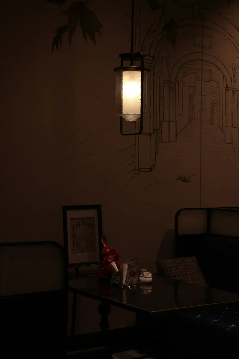 A hanging lantern over a dark dining room