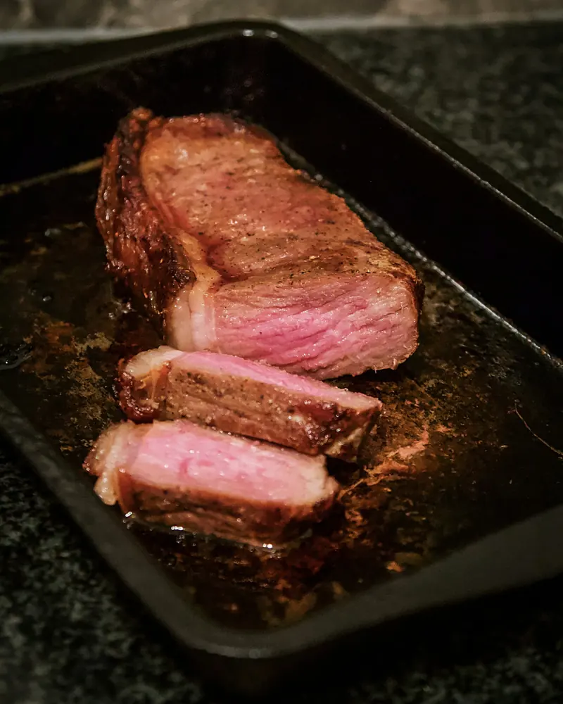 Sliced prime rib on a dark tray