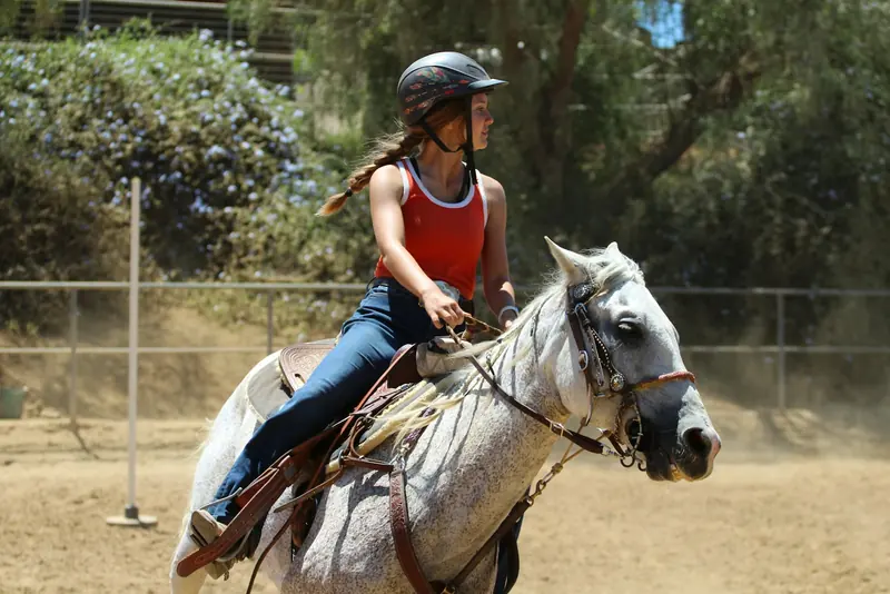 A rider rounding a turn in the arena below the hills