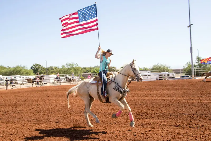 A rider carrying the flag at a lope for the grand entry