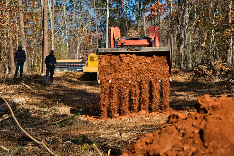 An excavator digging while two people watch