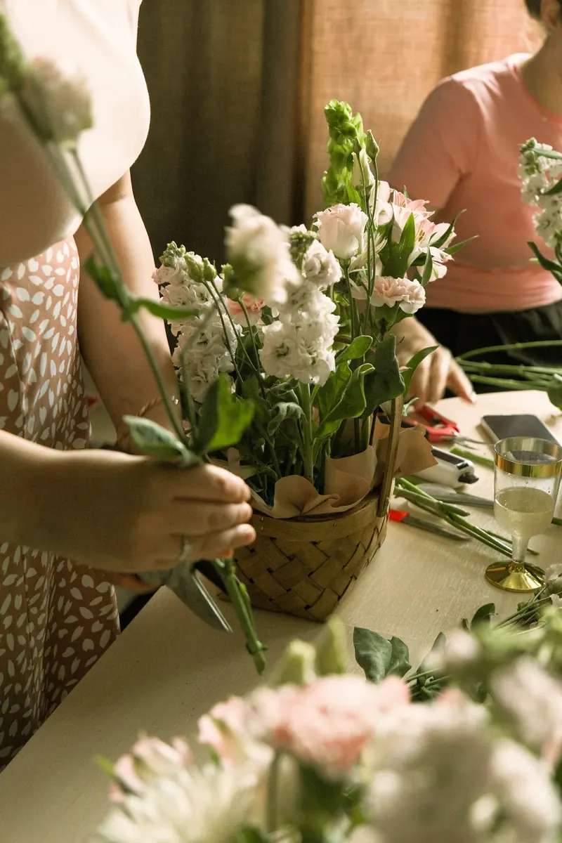 Arranging fresh flowers in a basket