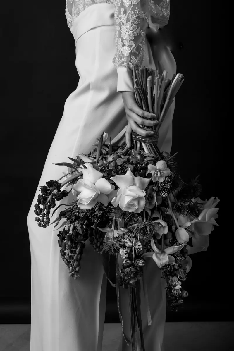 A bouquet held low against a white dress