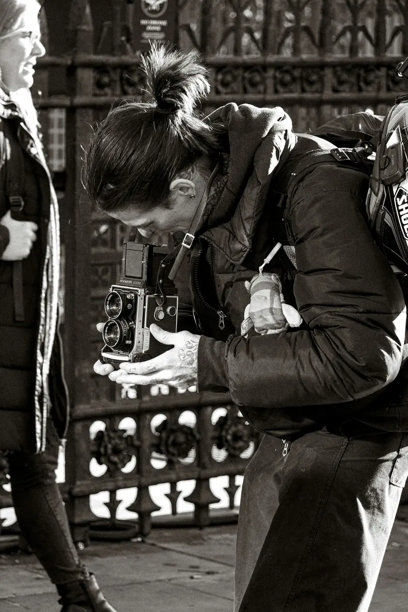 A photographer looking down into a vintage camera