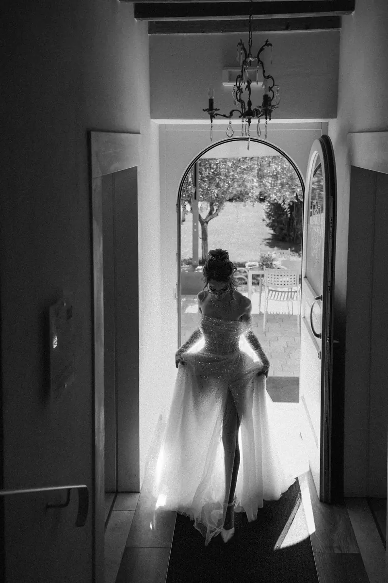 A bride walking through a doorway toward a garden