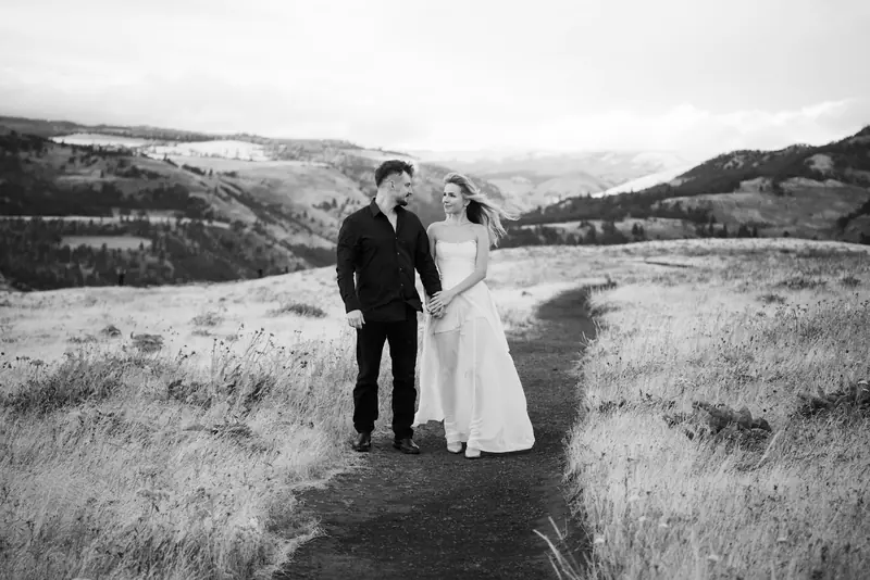 A couple holding hands on a trail in the hills