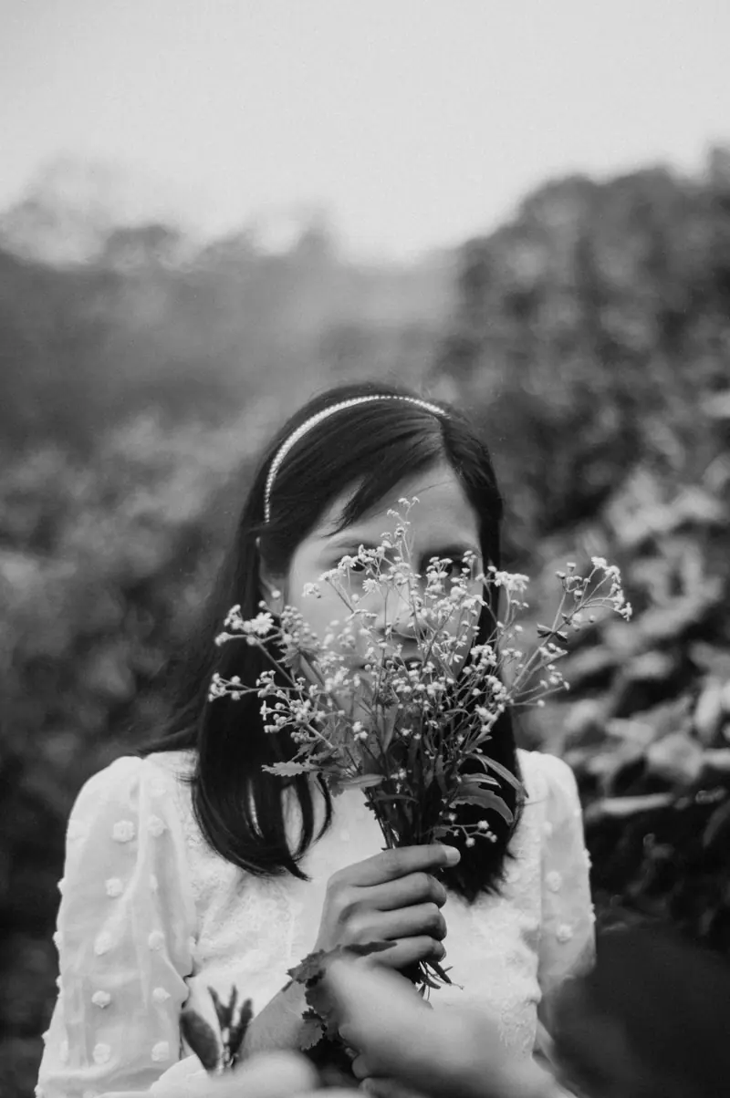 A woman holding wildflowers up to her face