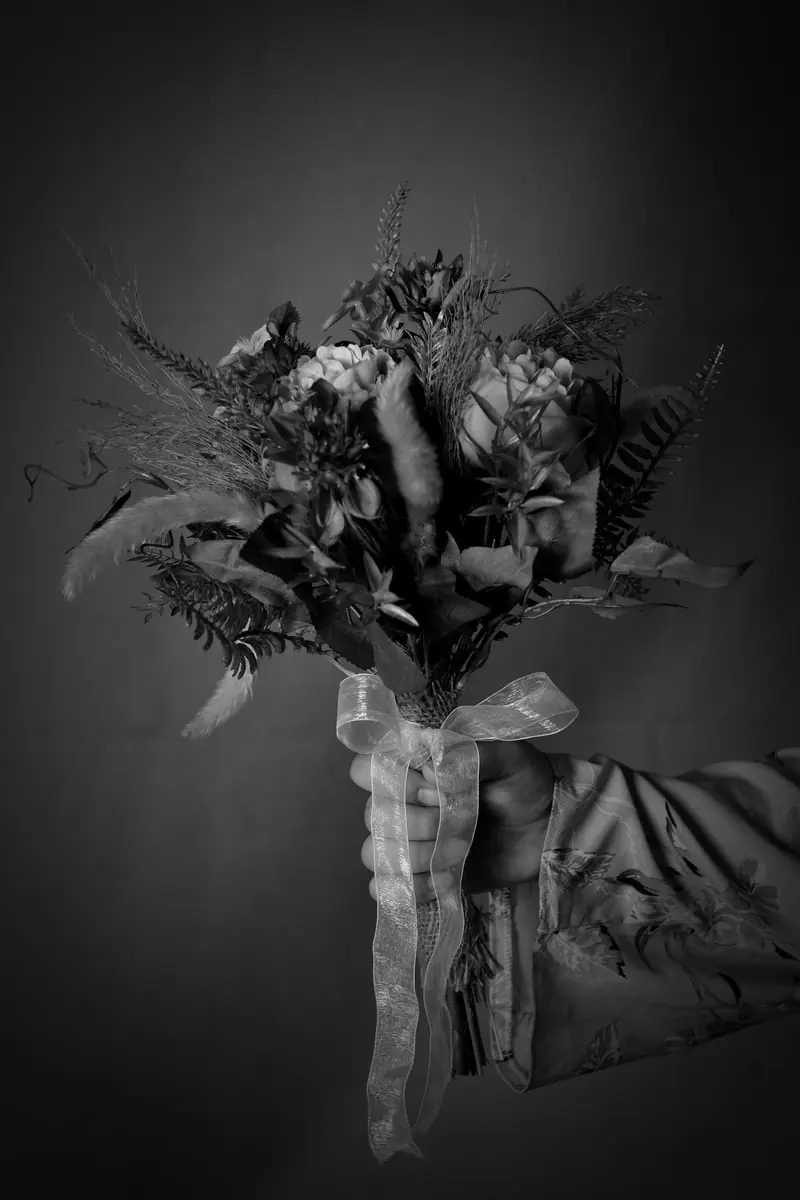 A bouquet tied with ribbon, held in low light