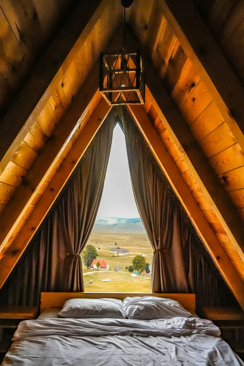 An A-frame bedroom looking out at the hills