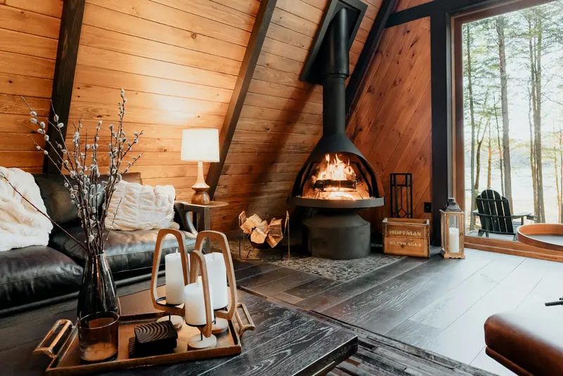 A wood-paneled cabin living room with a fire going
