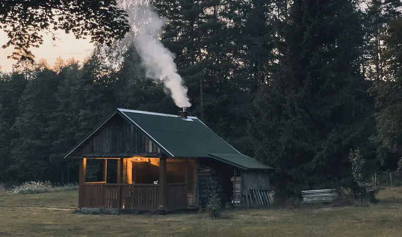 A small cabin with smoke coming from the chimney