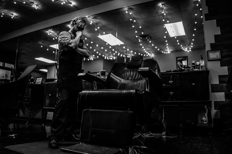 A barber at work under the shop lights