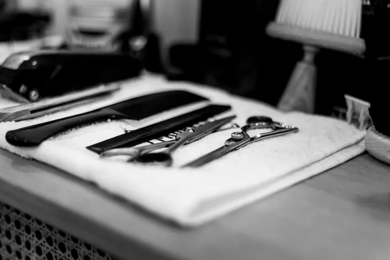 Scissors, a razor and combs laid on a towel