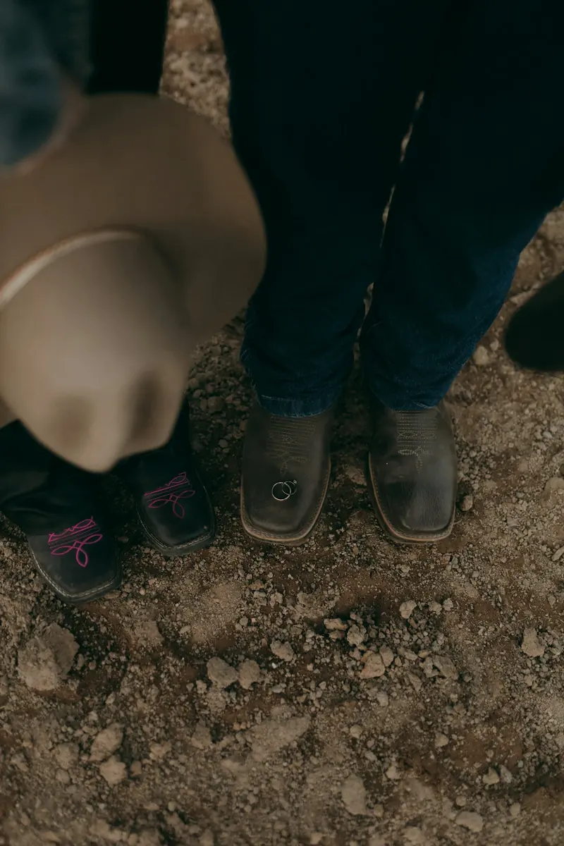 Cowboy boots and a wedding ring on rocky ground