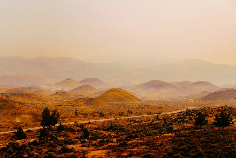Hazy desert hills and a road at sunset