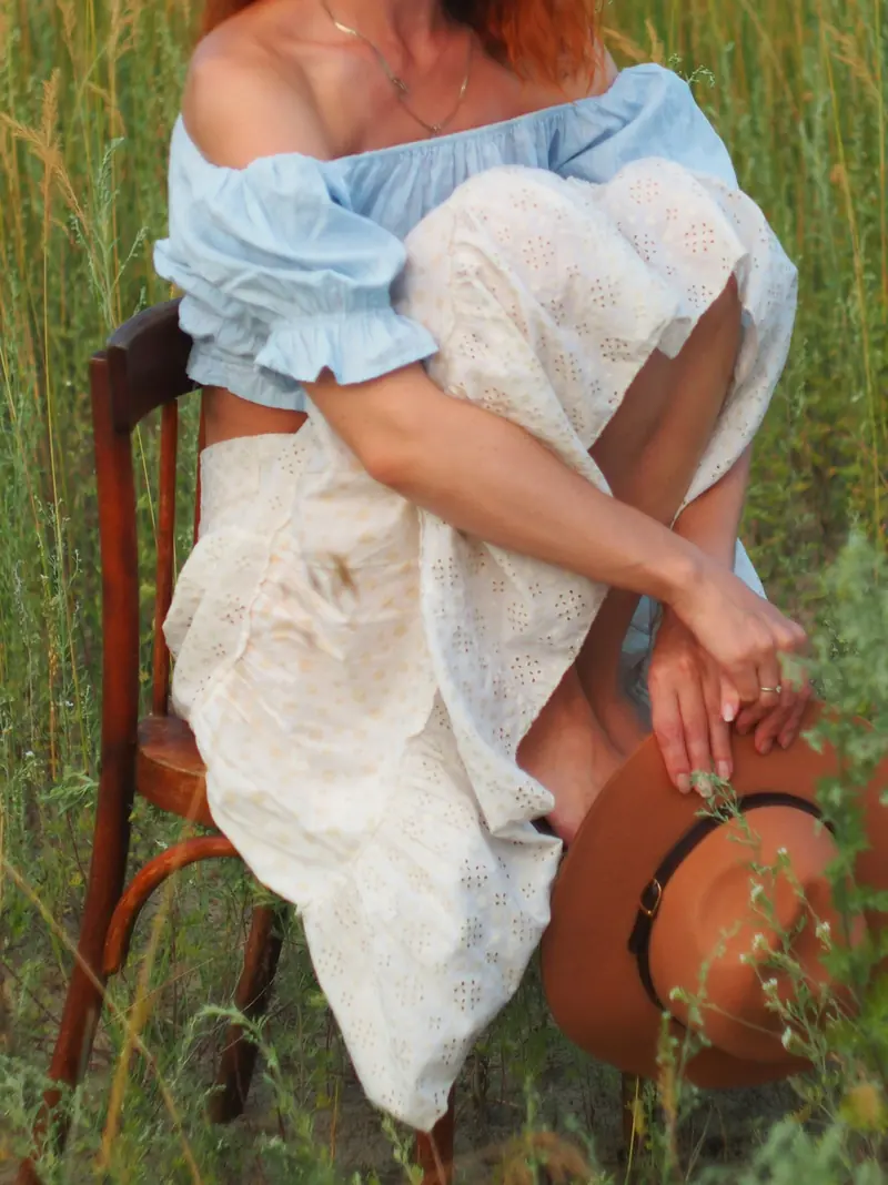 A woman sitting on a chair out in a field