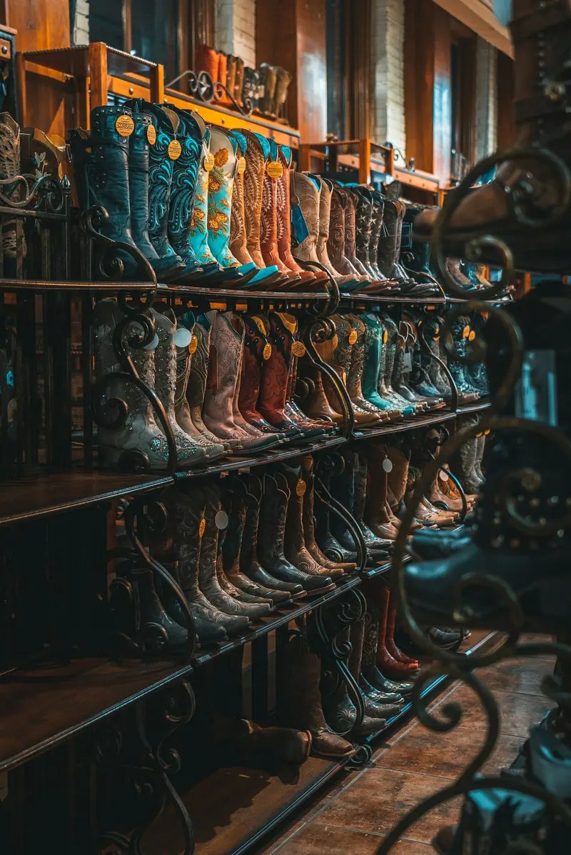 Cowboy boots lined up on a metal rack