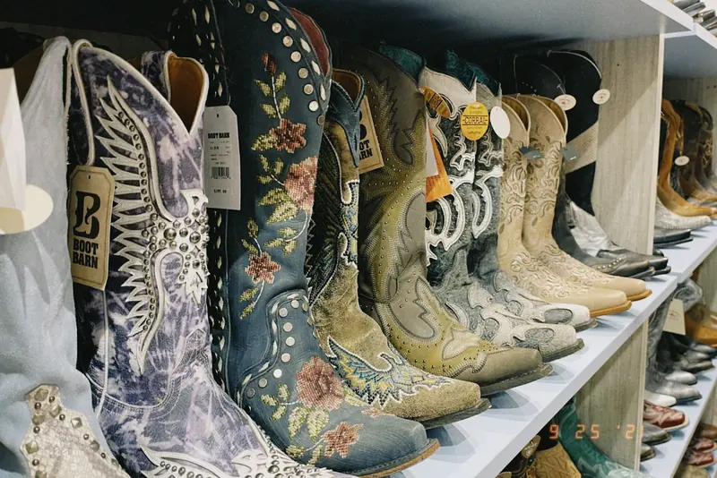 Stitched cowboy boots in many colors on a store shelf