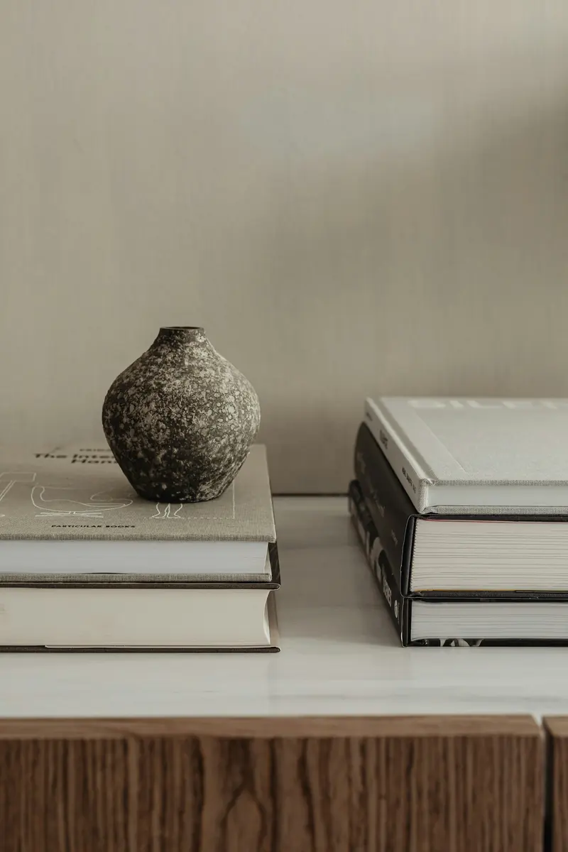 A stone vase between two stacks of books