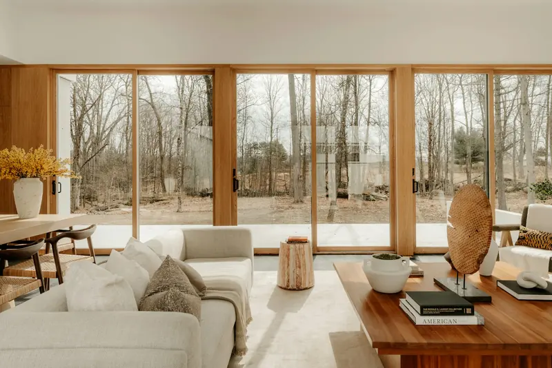 A living room with big windows looking out on trees