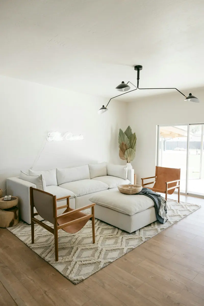 A white sofa beside a wood chair