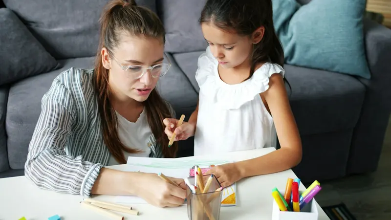 A mother and daughter drawing together at a table