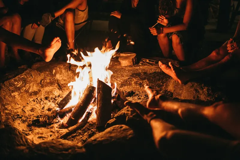 Friends sitting around a bonfire at night