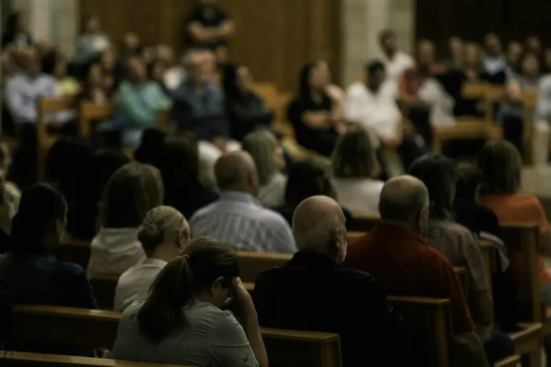 People seated in wooden pews during a Sunday service