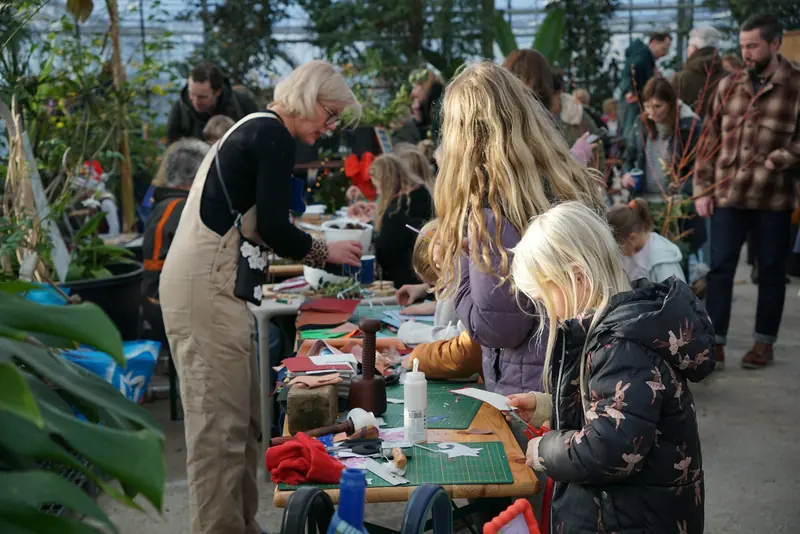 Kids and grown-ups working on crafts at long tables