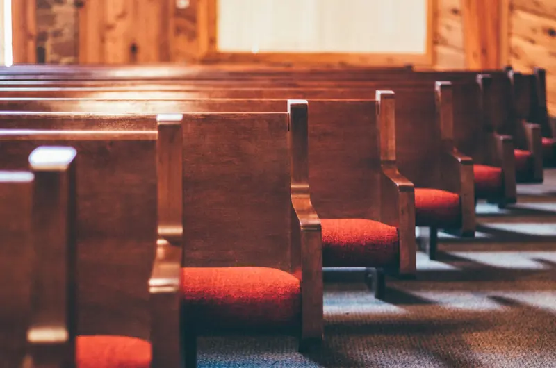 Rows of wooden pews in an empty church