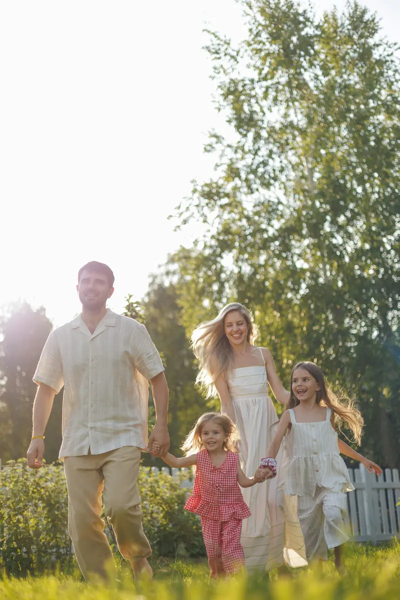 A family running together across a sunny yard