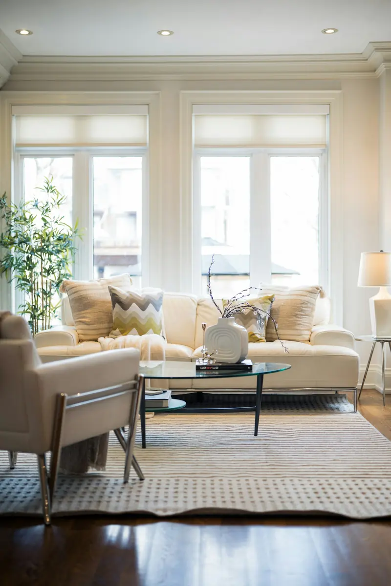 A bright living room with a white sofa and an armchair